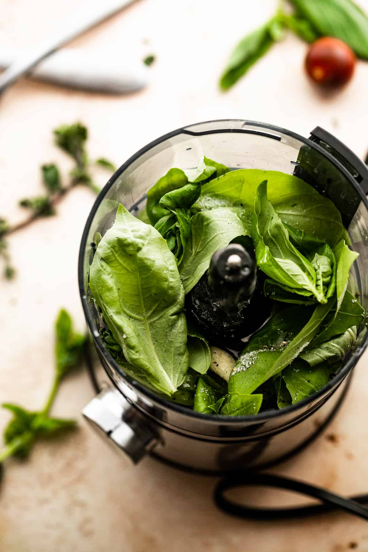 Adding the ingredients for basil garlic dressing to a food processor.