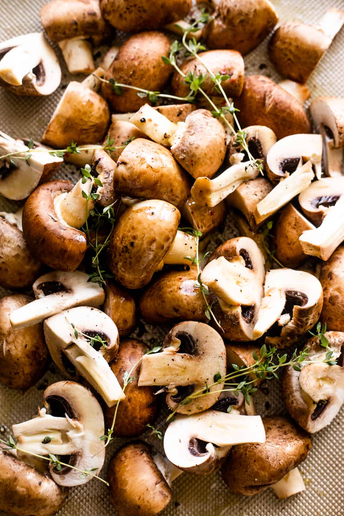 halved mushrooms pulled together in a bunch and topped with sprigs of fresh thyme.