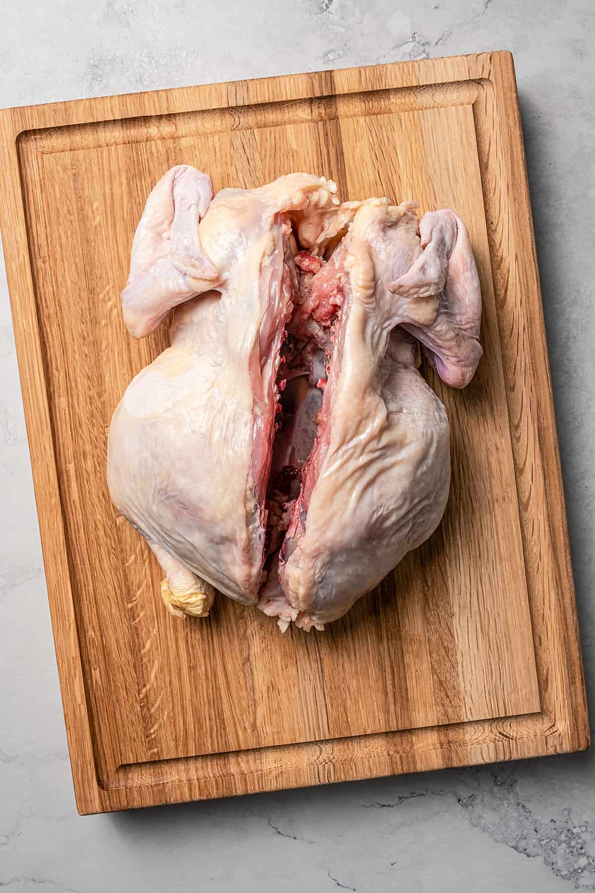 Overhead shot of a whole chicken with the backbone removed.