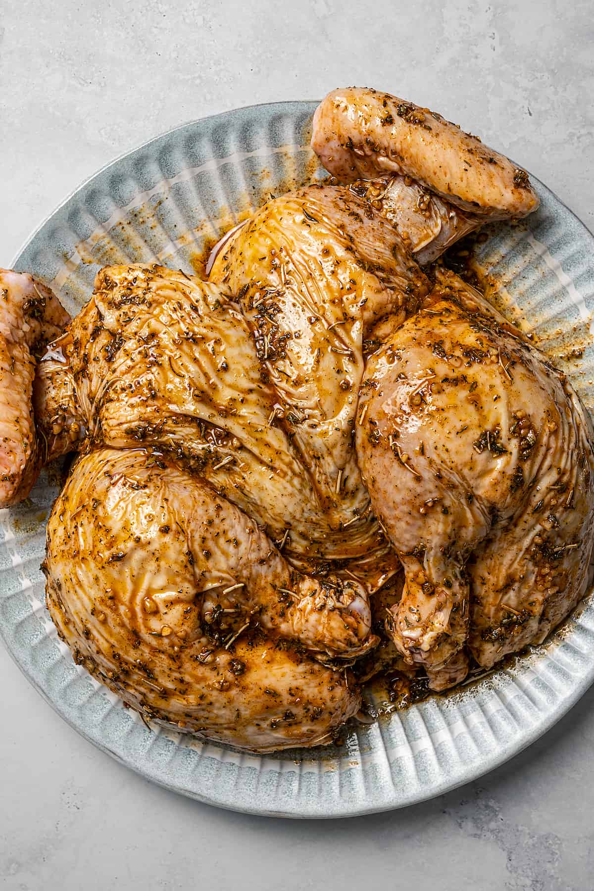 Seasoned, raw spatchcock chicken.