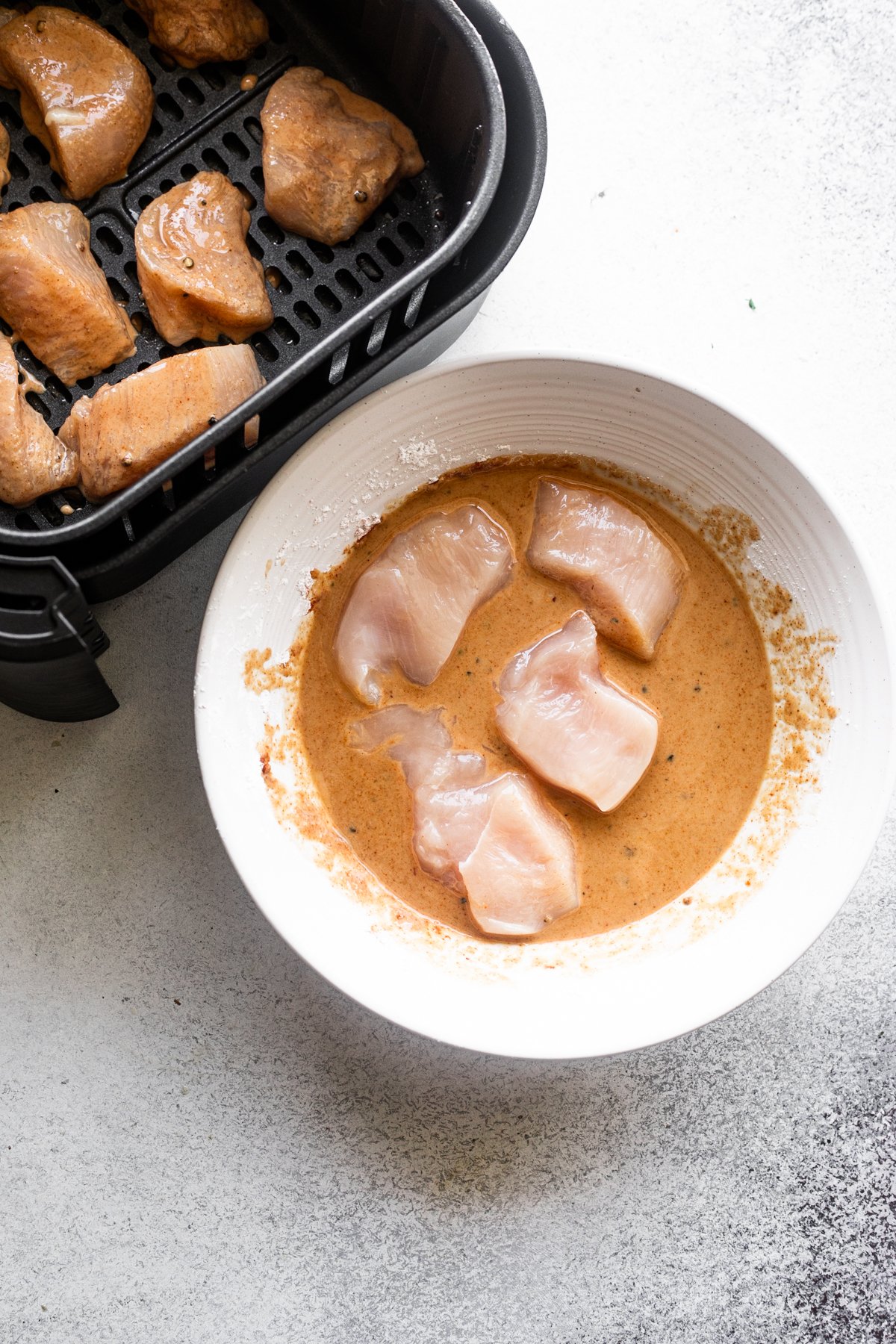 coating raw chicken bites with marinade.