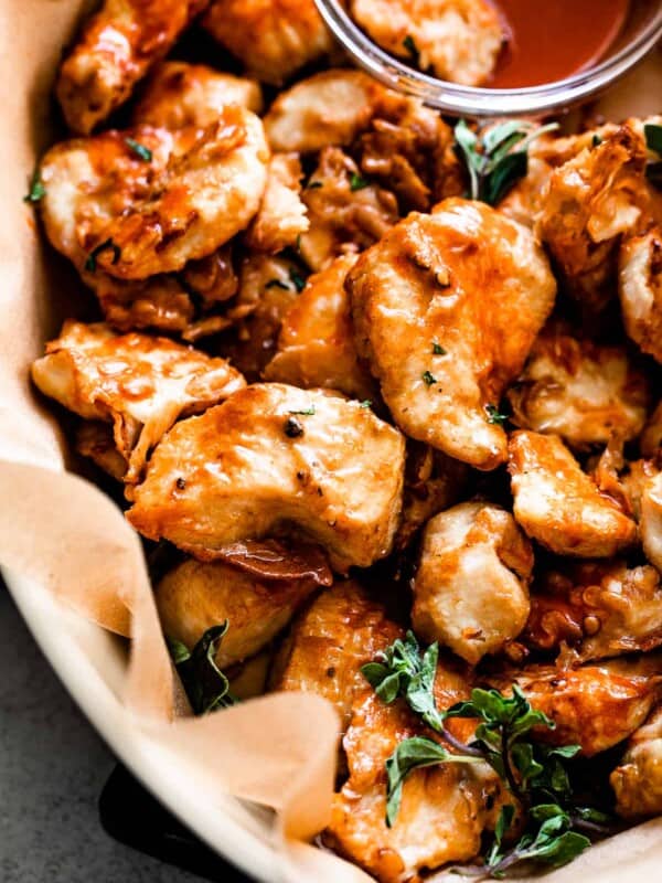 up close shot of air fryer buffalo chicken bites served in a basket with side bowl of blue cheese dressing.