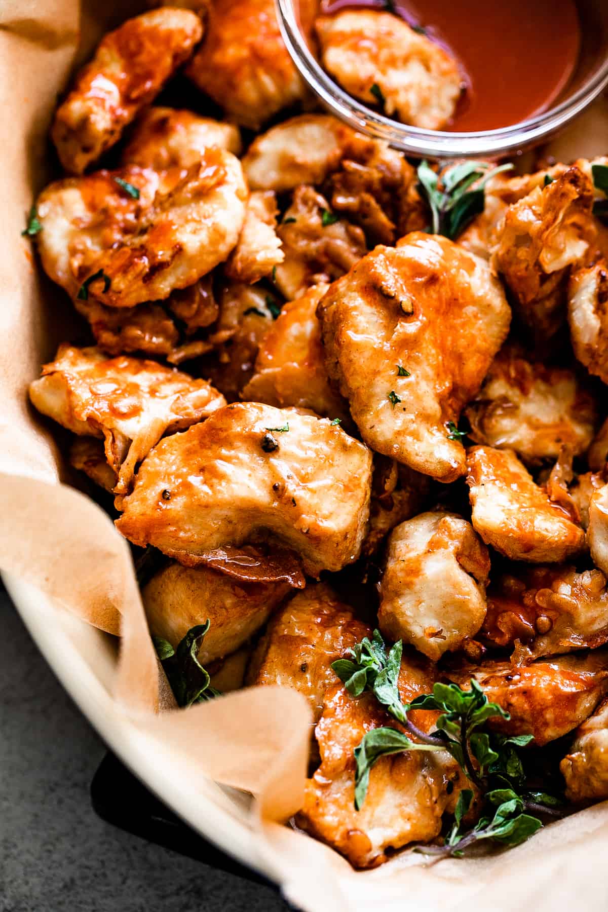 up close shot of air fryer buffalo chicken bites served in a basket with side bowl of blue cheese dressing.