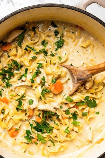 Egg noodles cooking in creamy soup.