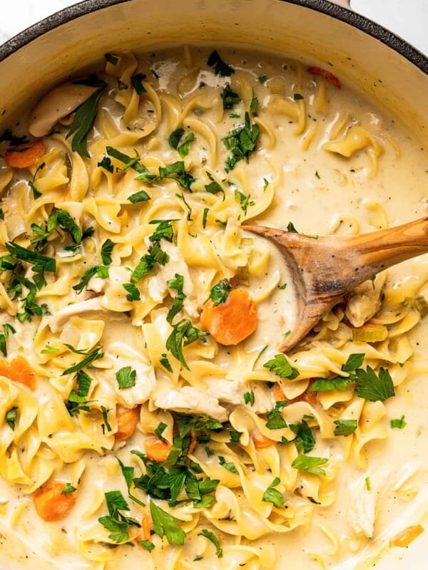 Egg noodles cooking in creamy soup.