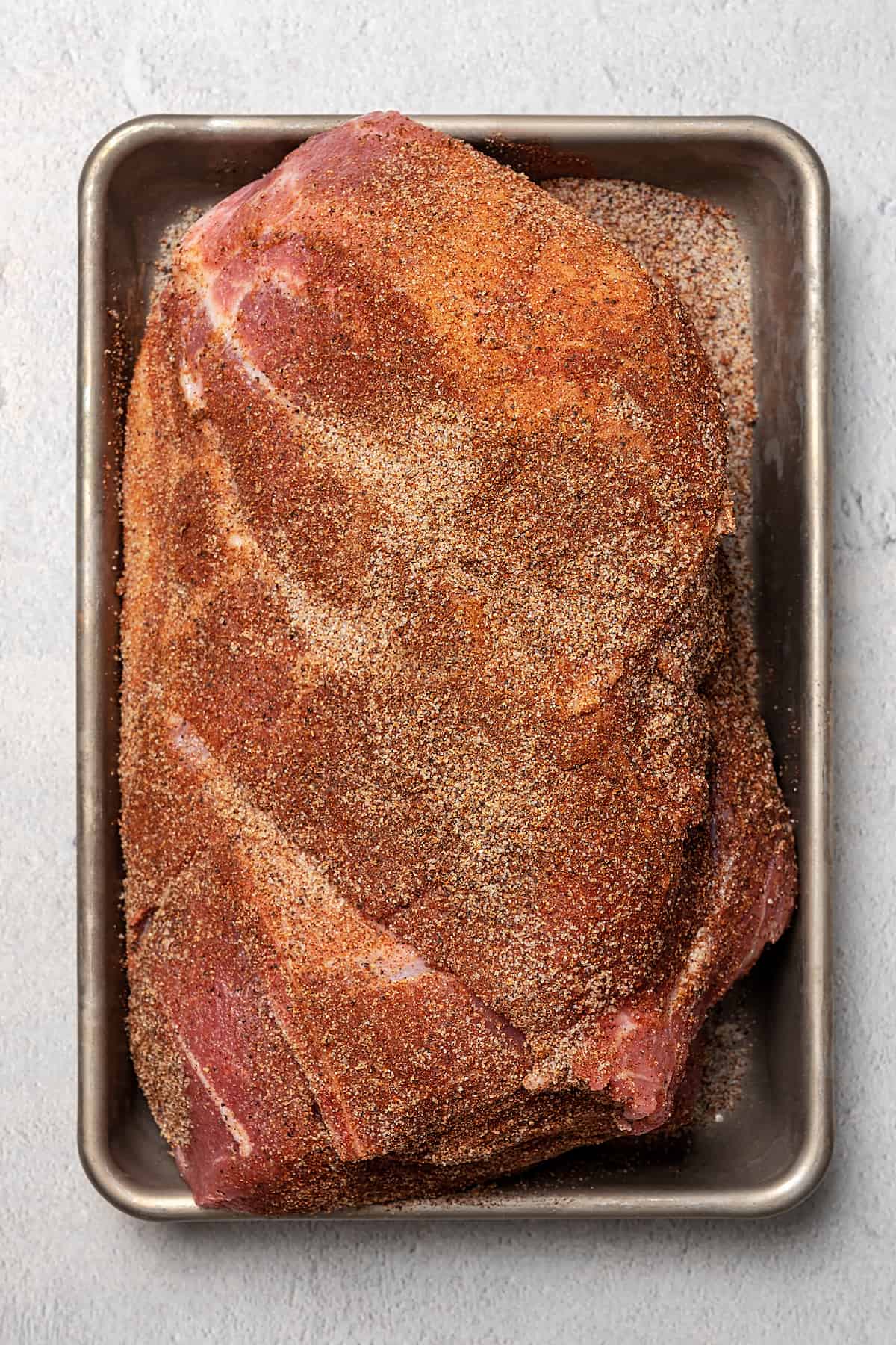 A large pork shoulder, rubbed with spices.