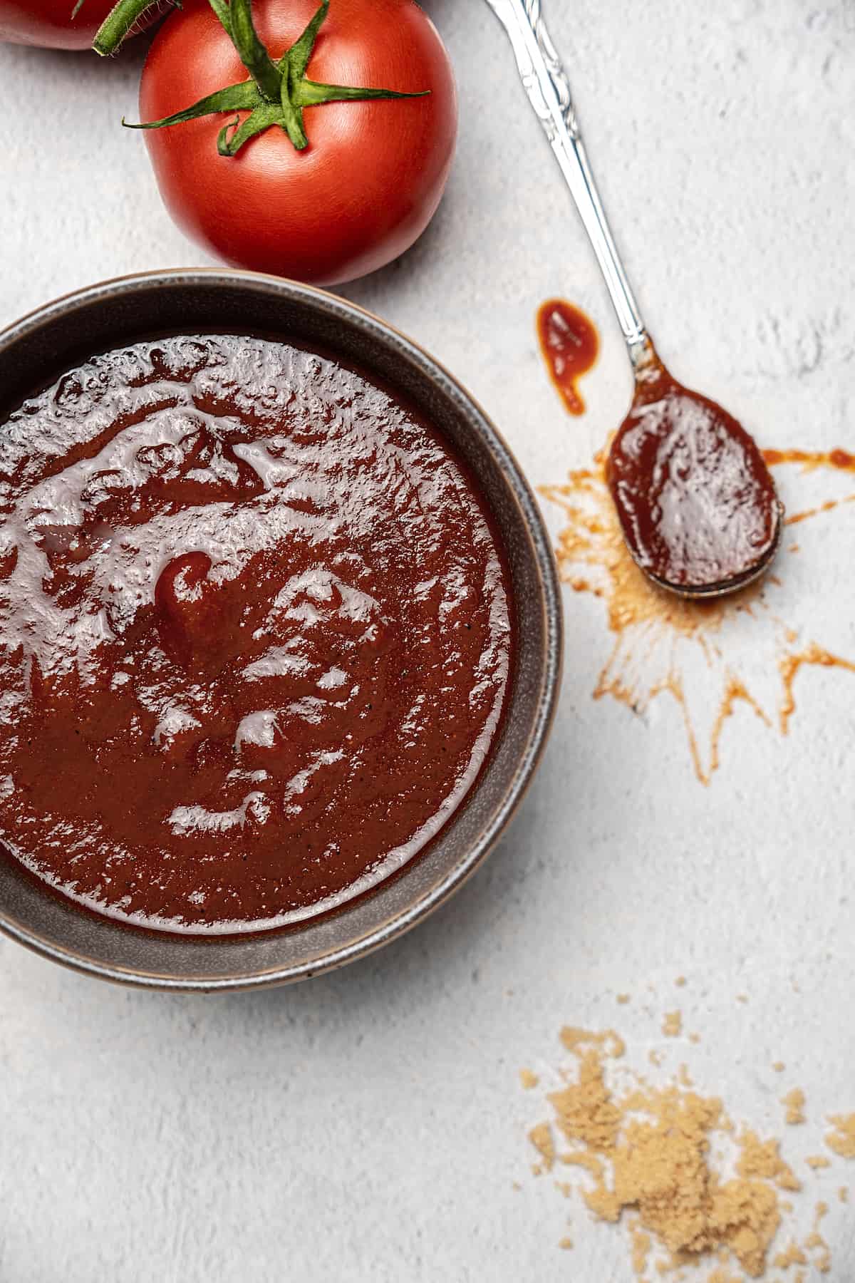 A bowl of barbecue sauce with a spoon.