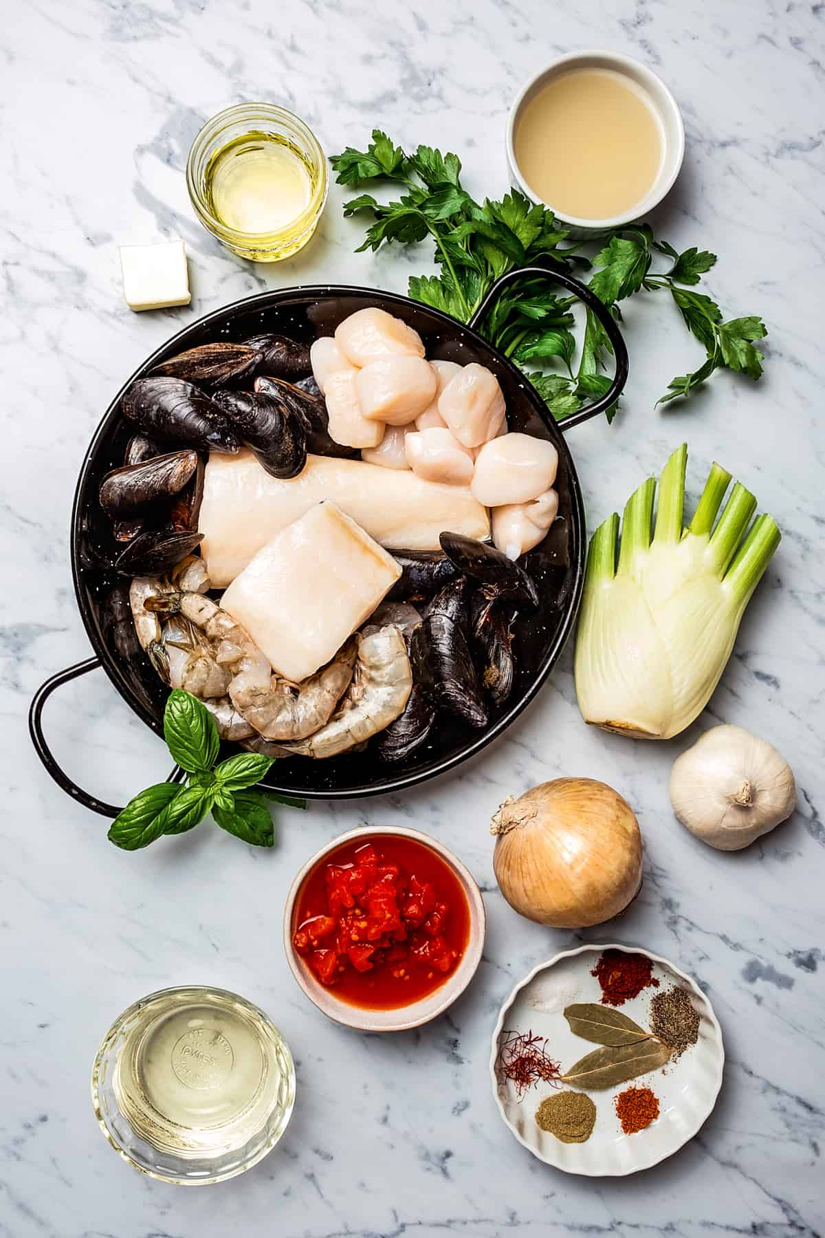 From top left: Butter, olive oil, parsley, clam juice, mussels, fish fillets, shrimp, a fennel bulb, tomatoes, onion, garlic, white wine, seasonings.