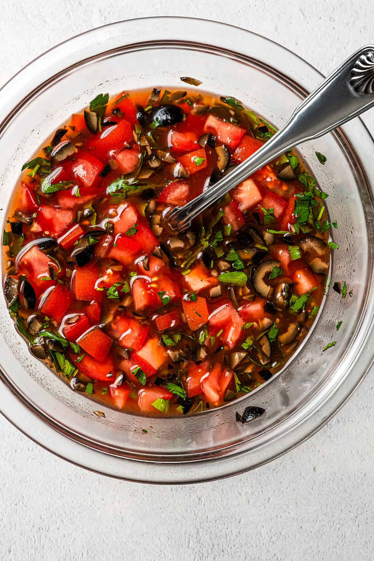 Tomatoes, vinaigrette, and other ingredients in a glass dish.