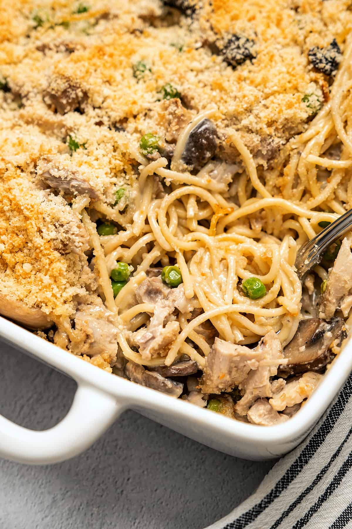 Digging into a casserole dish of pasta.