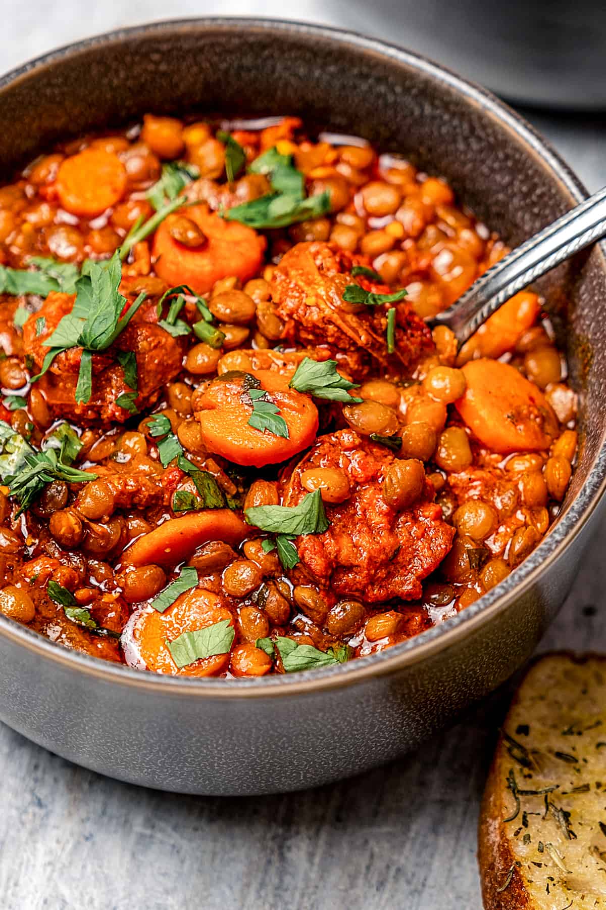 Spooning lentil soup out of a bowl.