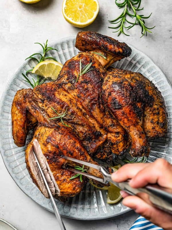 Carving a cooked whole chicken.