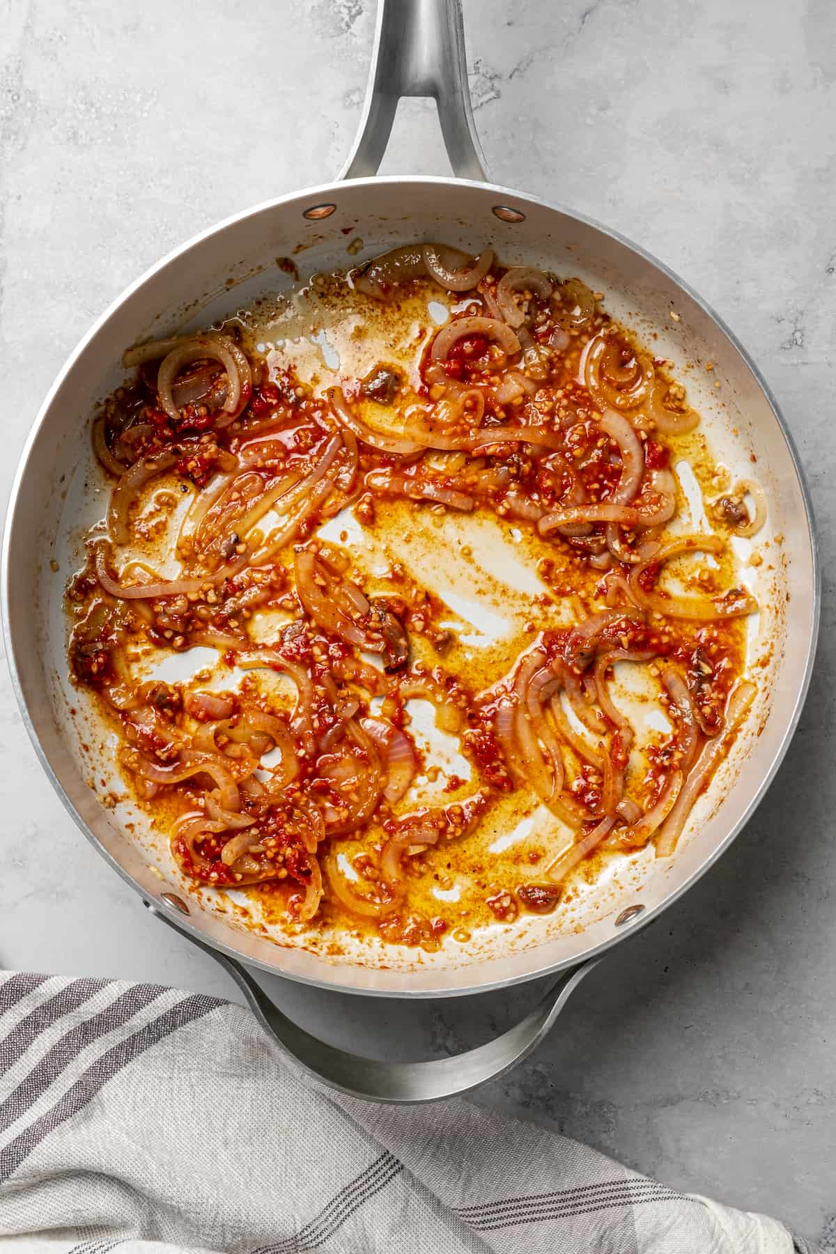 Onions cooked in tomato sauce in a heavy-bottomed skillet.