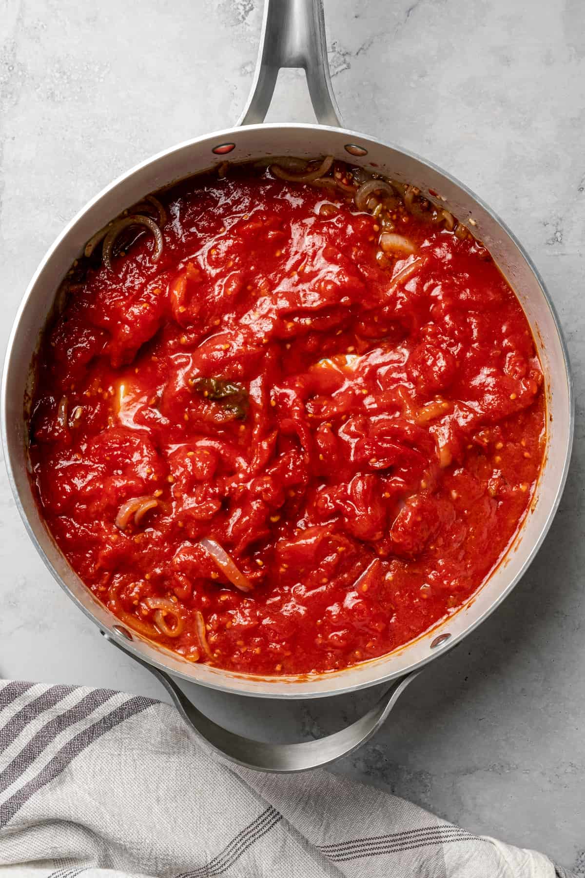A deep-sided skillet with tomato sauce.