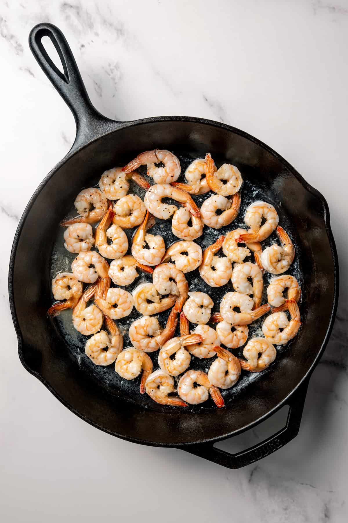 Cooked shrimp in a skillet.