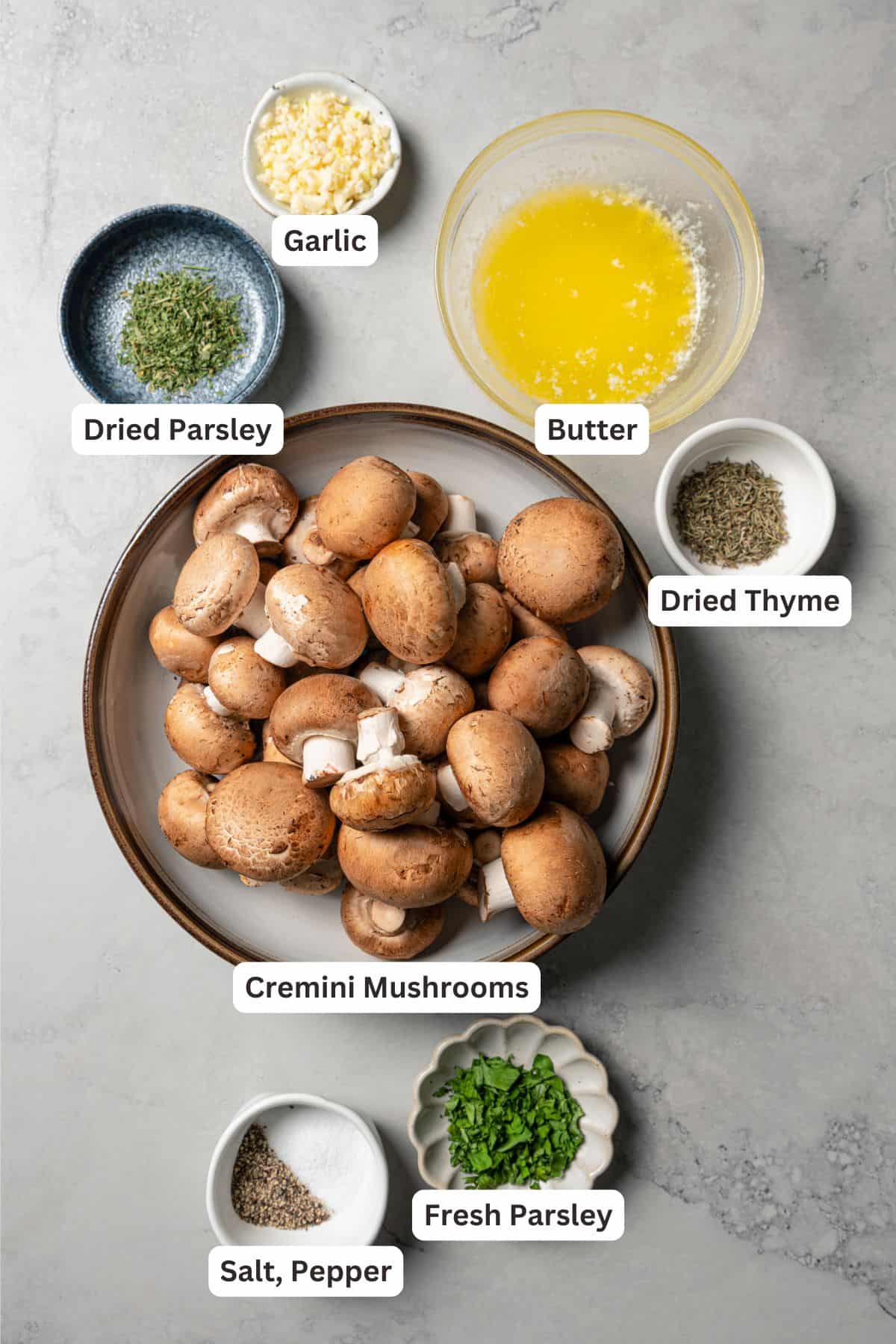 This roasted mushroom recipe combines buttery cremini mushrooms with garlic and herbs. It's a quick, easy side dish with only 5 ingredients! Roasted mushroom recipe ingredients with text labels overlaying each ingredient.