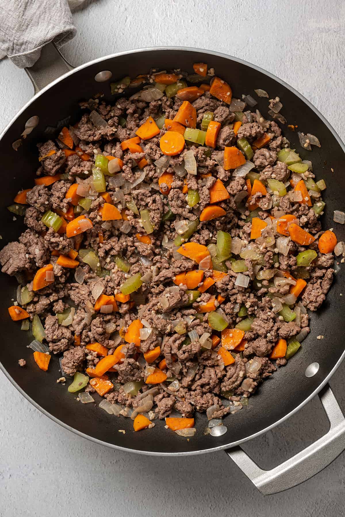 Ground beef and vegetables cooking in a pan.