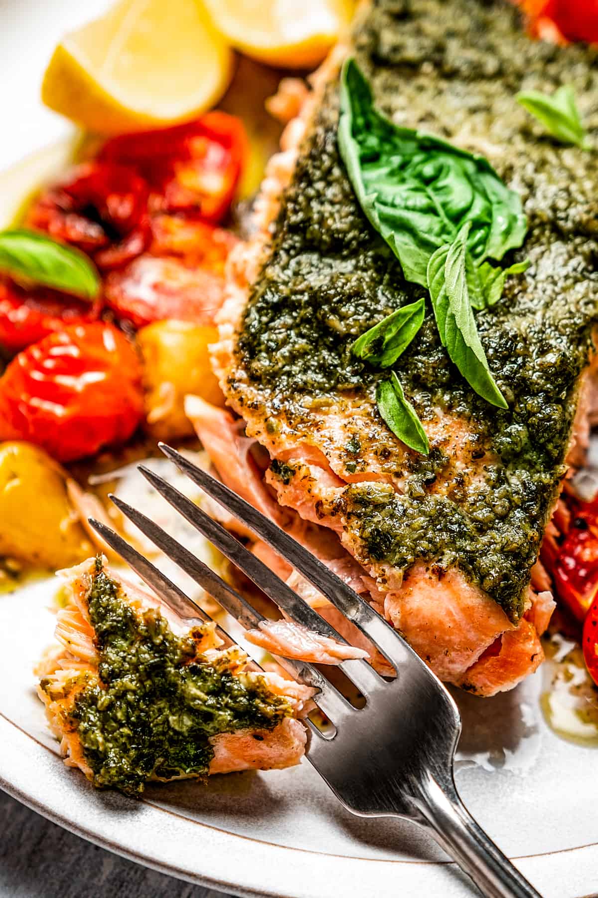 Cutting a bite of salmon with a fork.