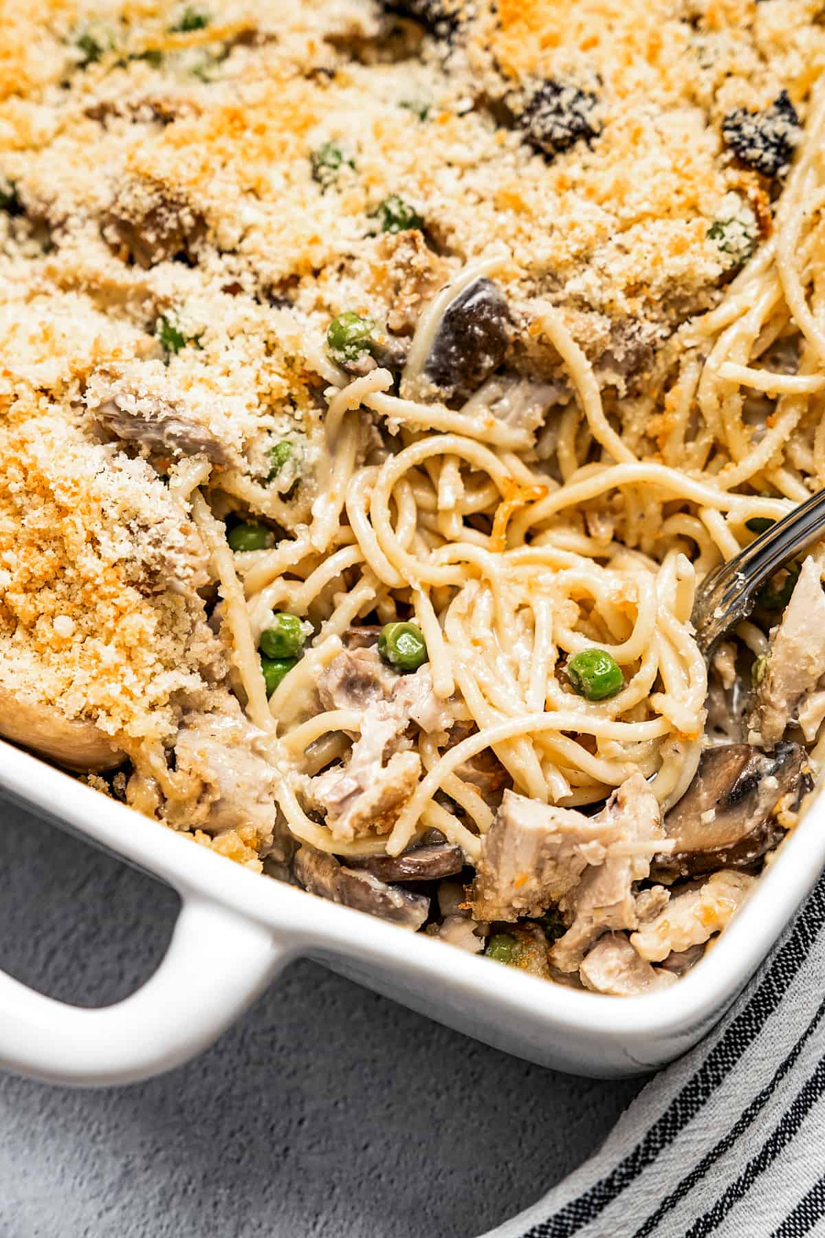 Digging into a casserole dish of pasta.