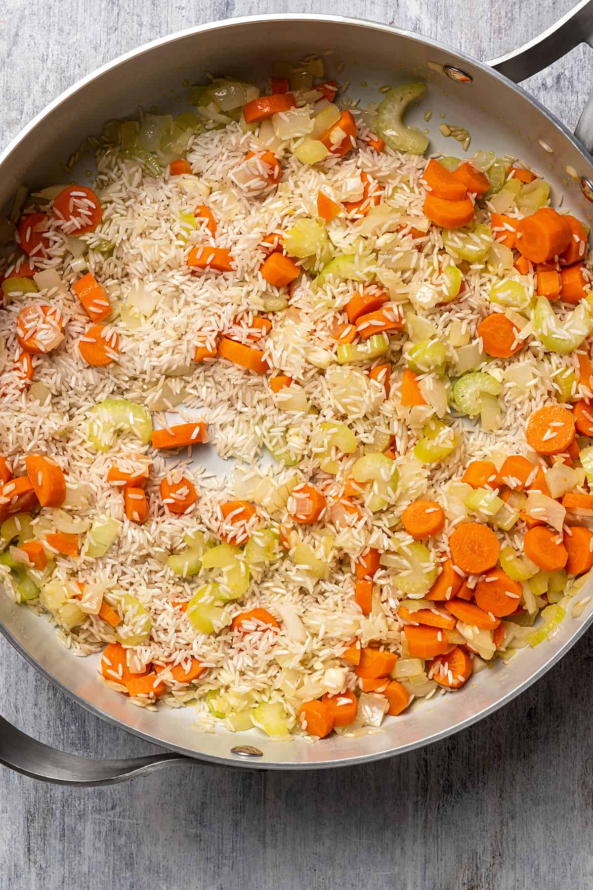 Toasting rice in a skillet of sauteed vegetables.