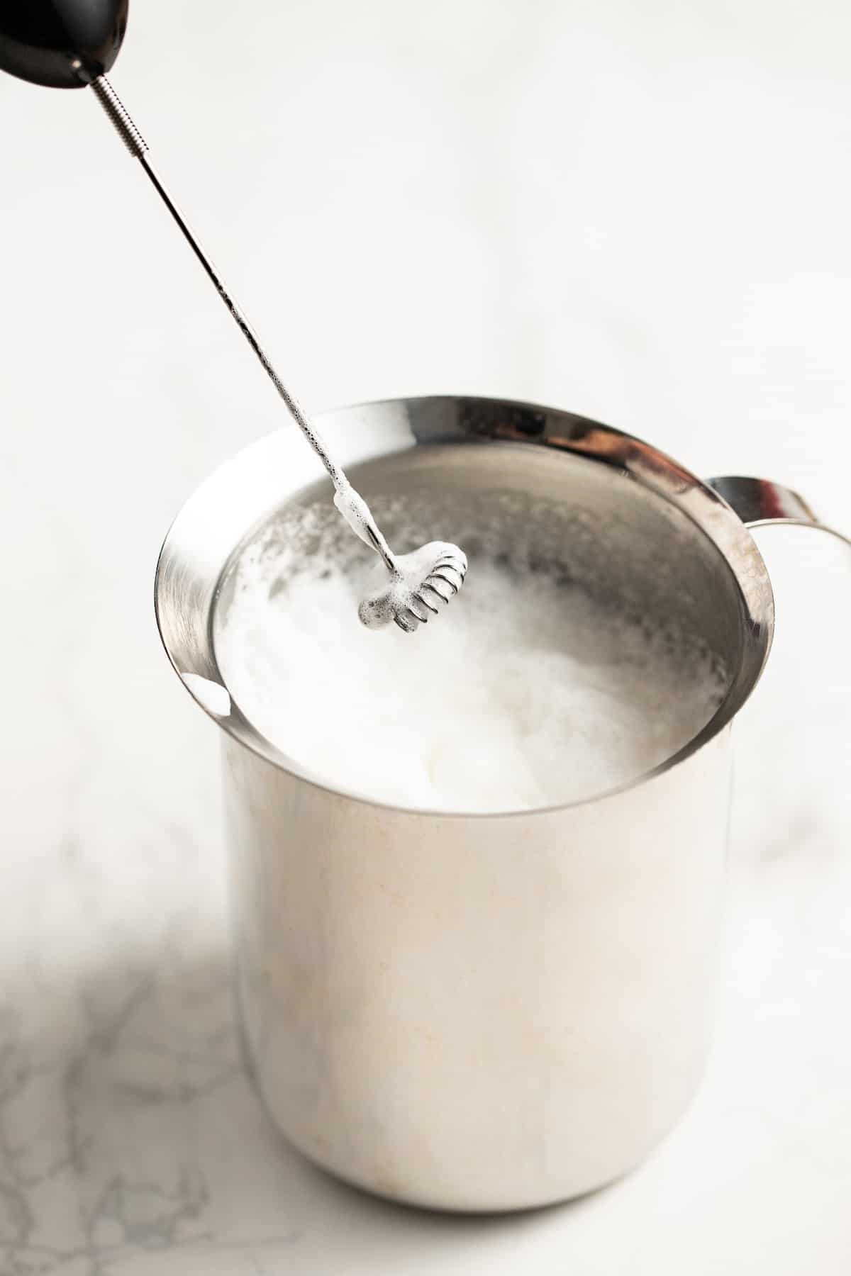 Using a frother to foam the milk.