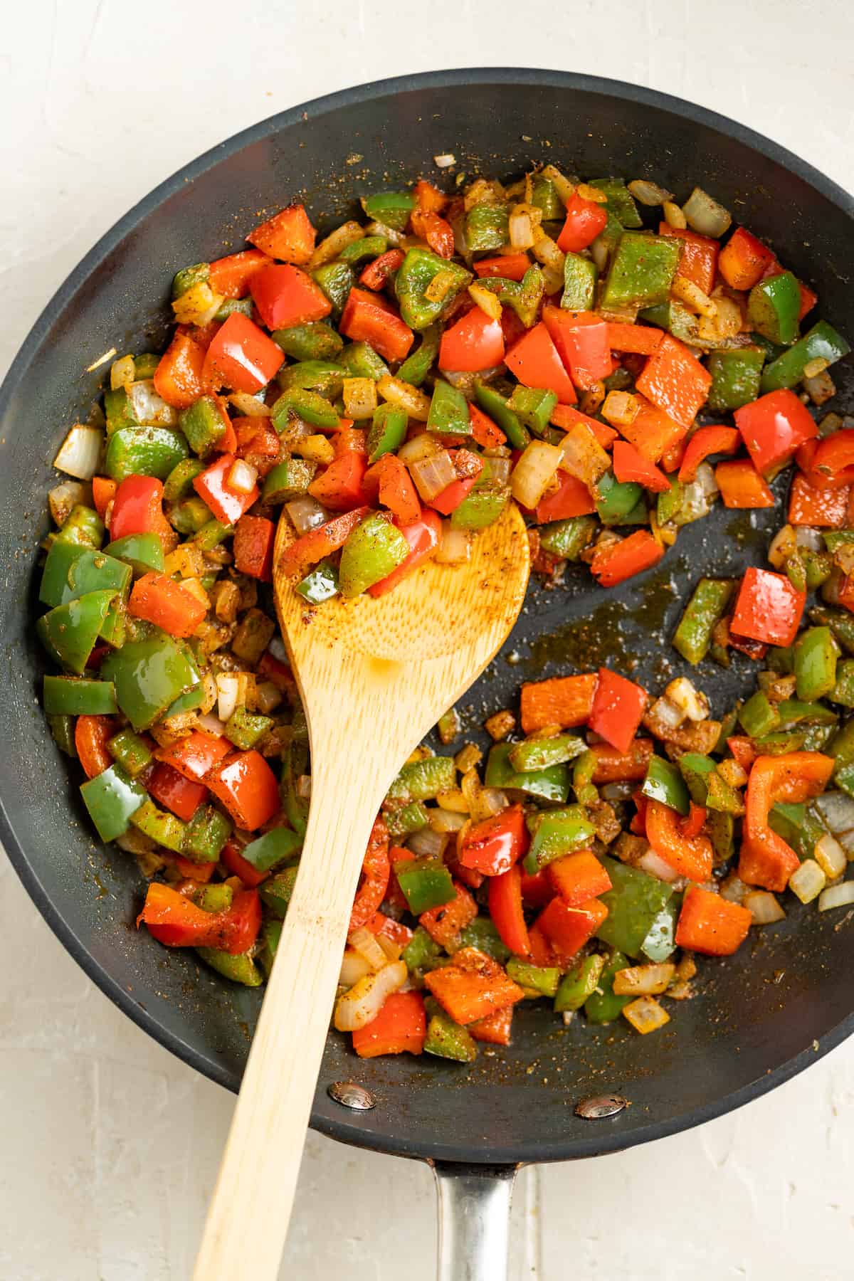 Cooking the onions and bell peppers in the pan.