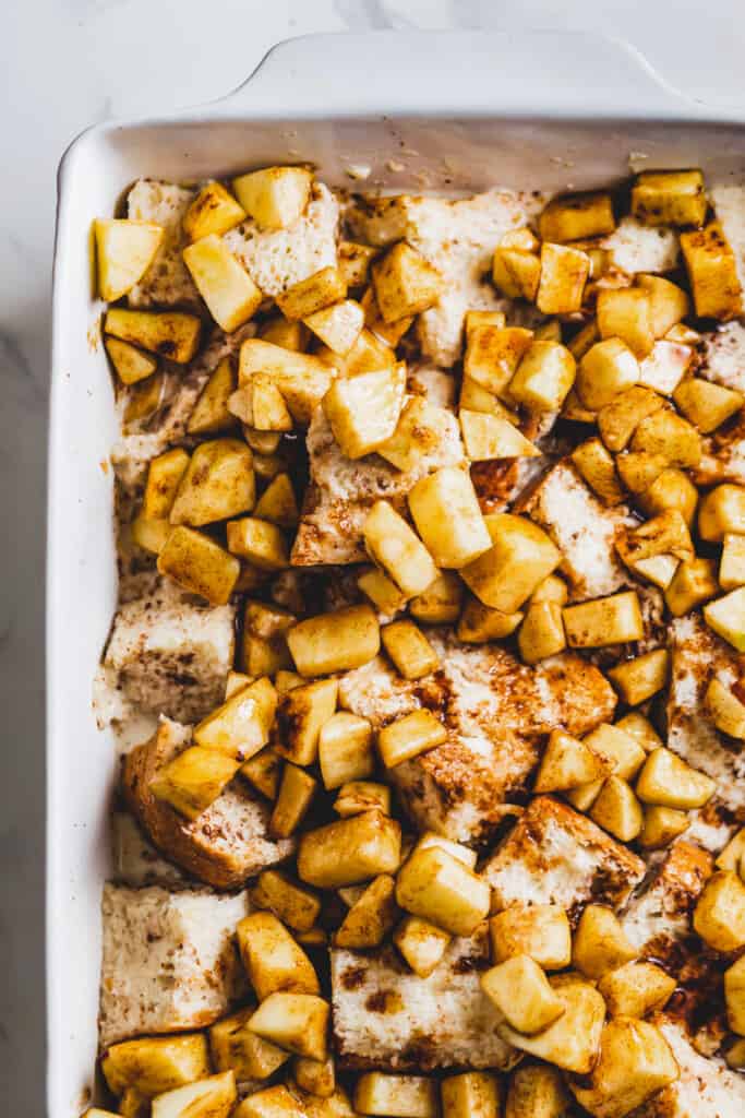 Assembling the apple cinnamon French toast bake in the baking dish.