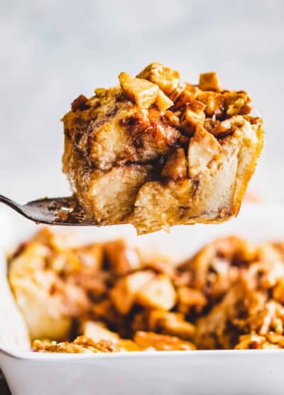 Spoonful of apple cinnamon French toast bake held up by a large spoon.