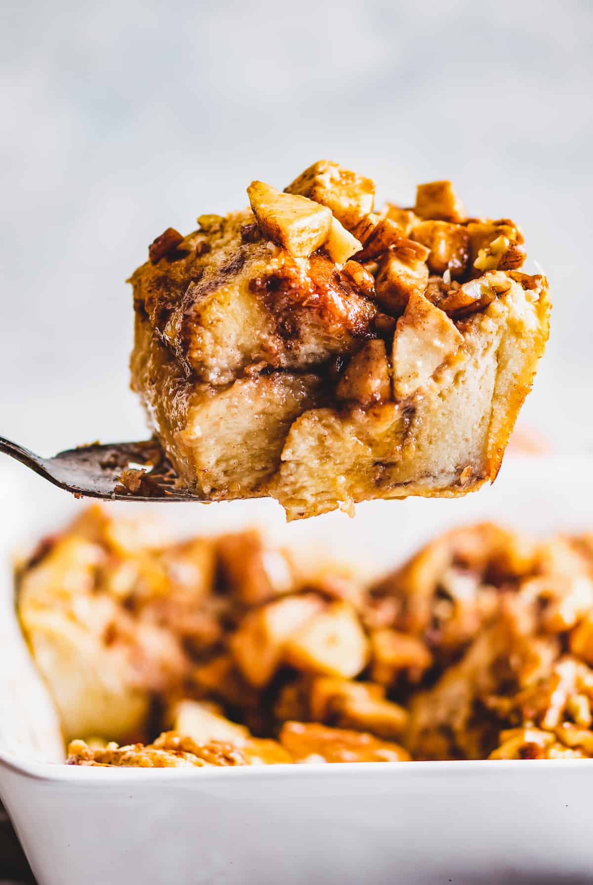 Spoonful of apple cinnamon French toast bake held up by a large spoon.