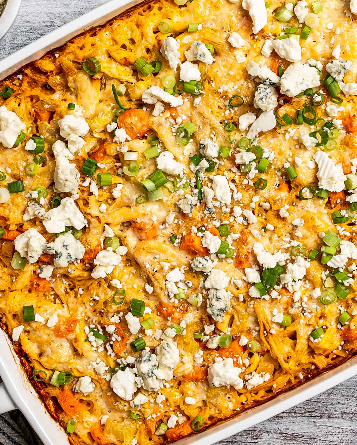 A large baking dish of buffalo chicken and rice.