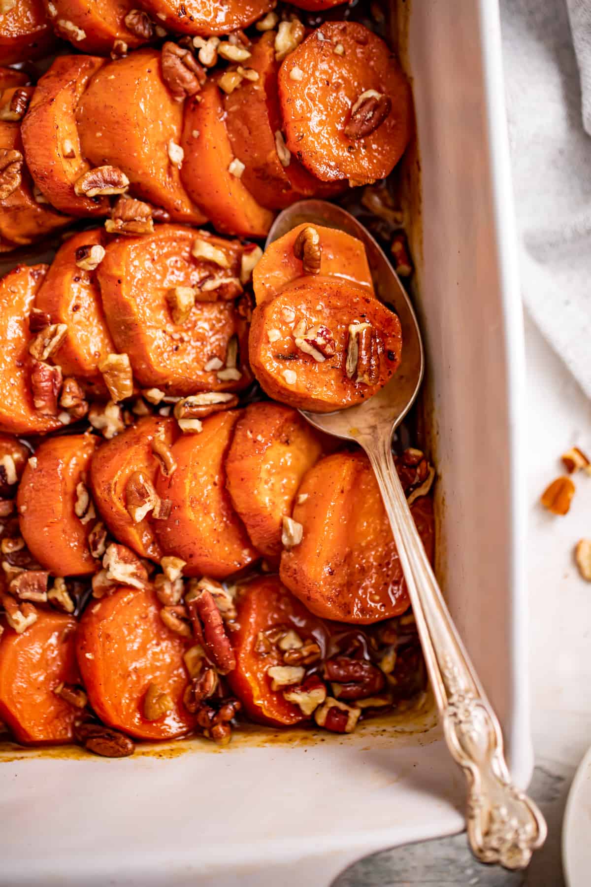 Baked Southern candied yams with pecans on top.