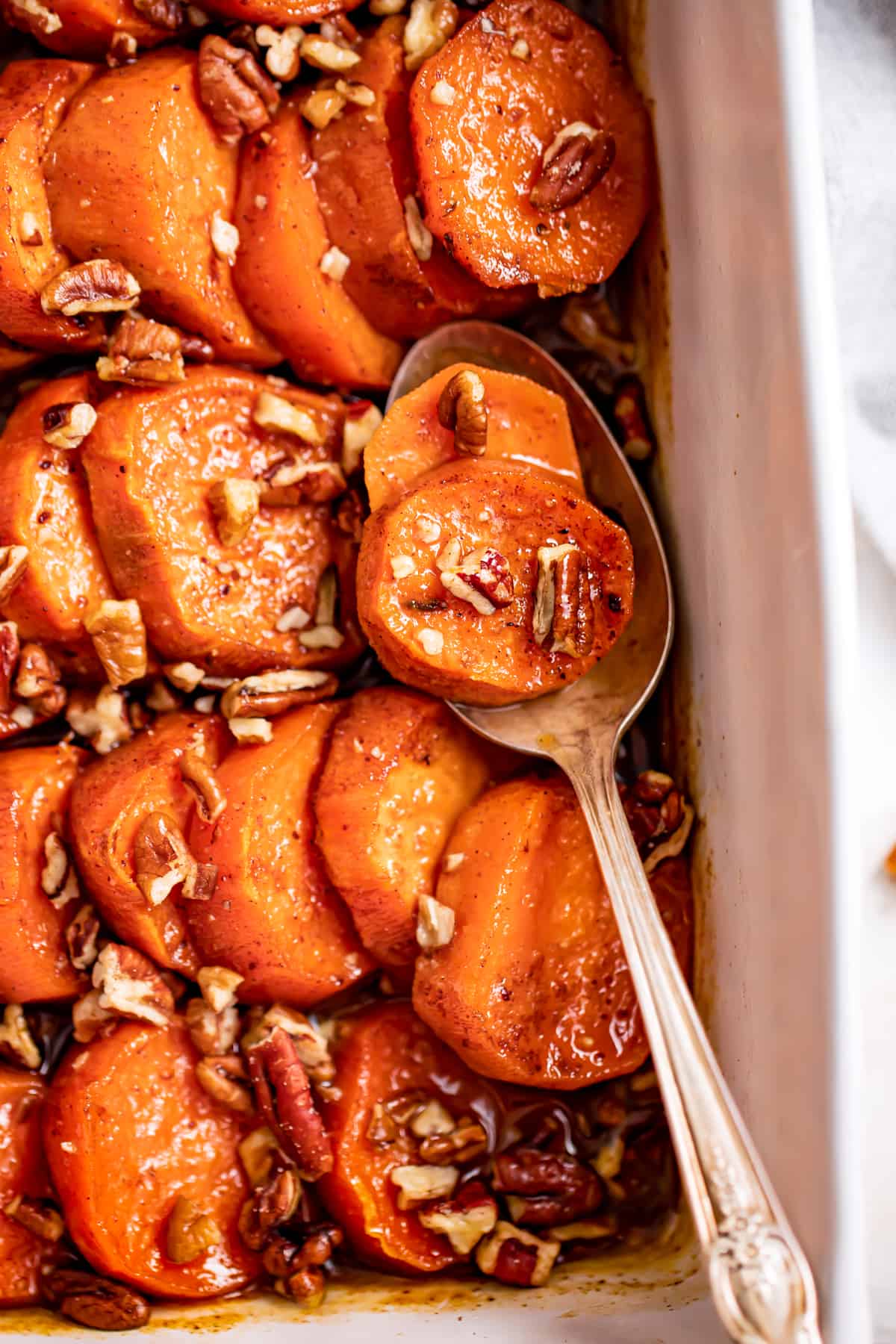Baked Southern candied yams with pecans on top.