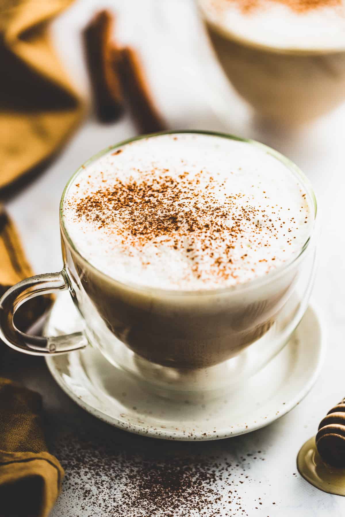 Angled shot of dirty chai latte in a glass mug.