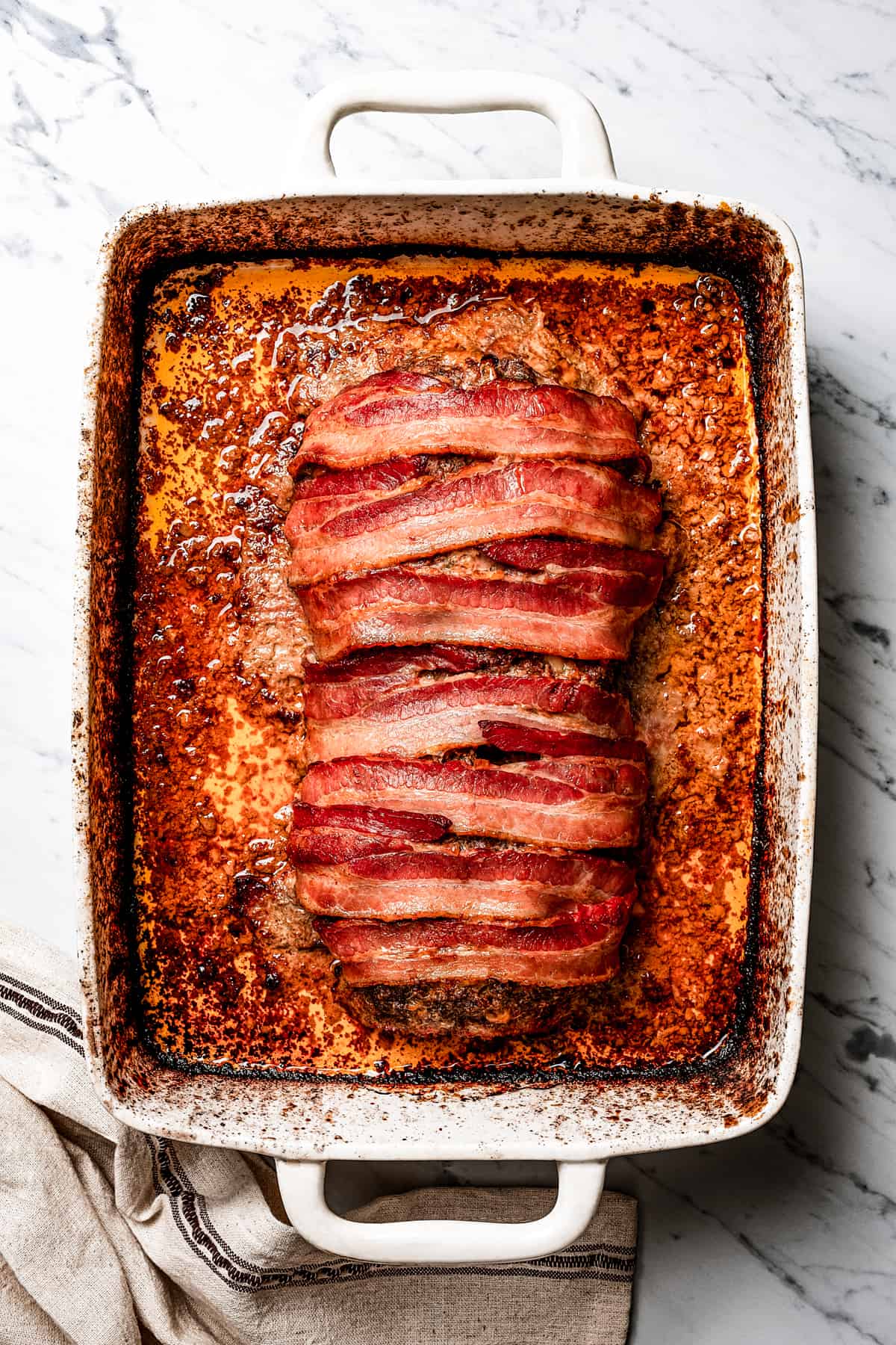 A baked meatloaf in a baking dish.