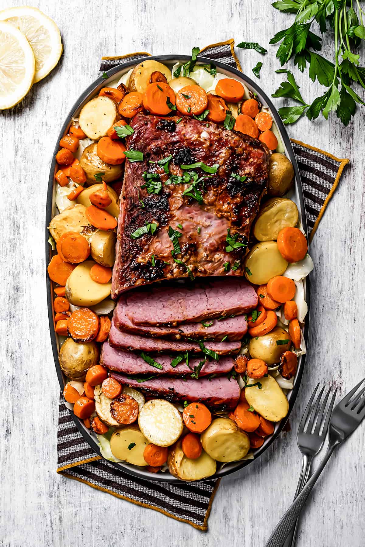 overhead shot of an oval serving platter of corned beef and vegetables.