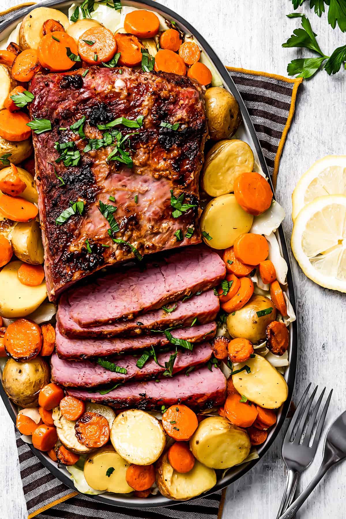 Sliced air fryer corned beef surrounded by vegetables.