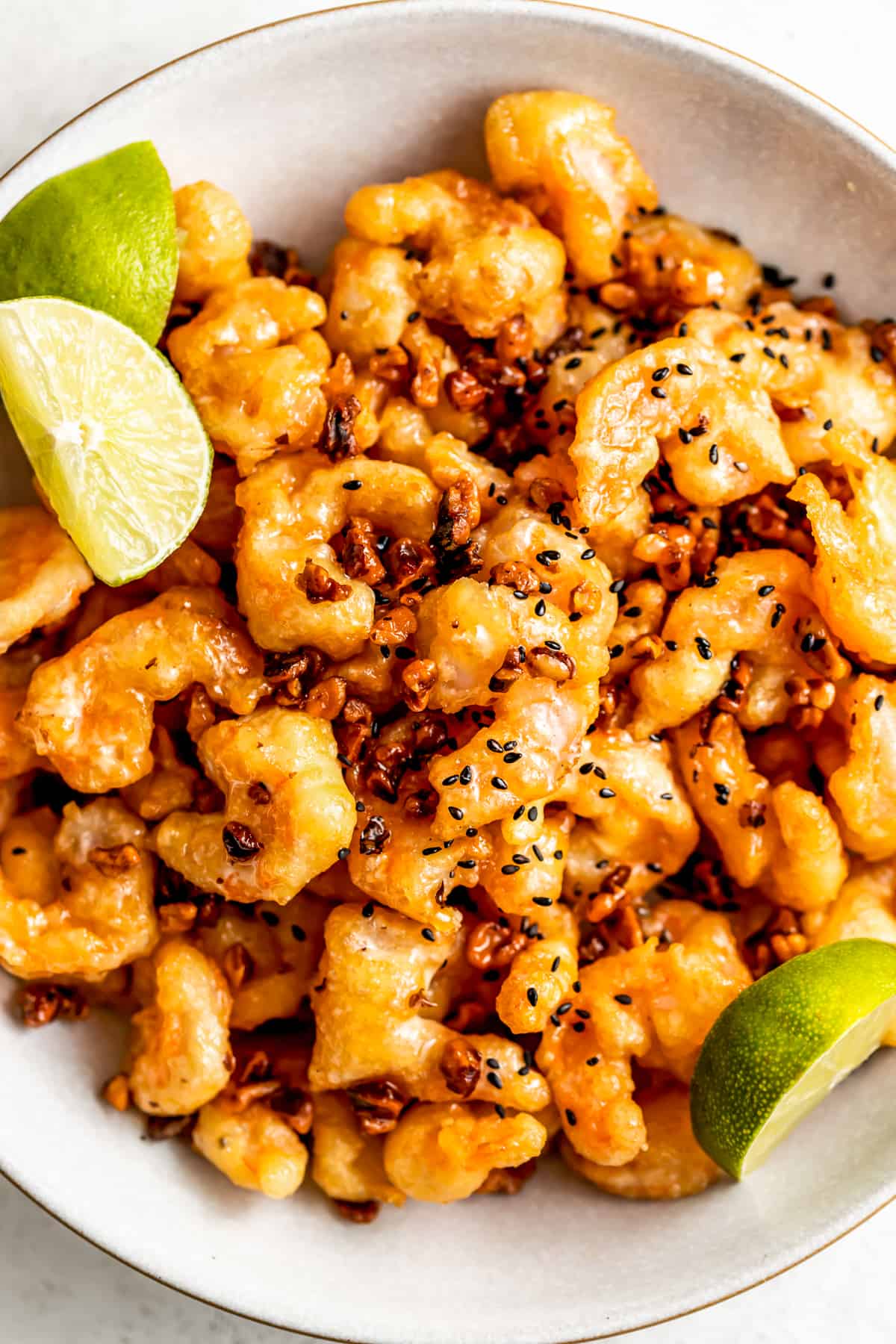Honey walnut prawns with sesame seeds and a lime wedge.