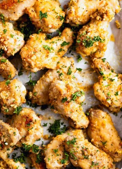 Close-up of lemon pepper wings garnished with parsley and parmesan.