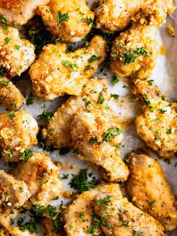 Close-up of lemon pepper wings garnished with parsley and parmesan.