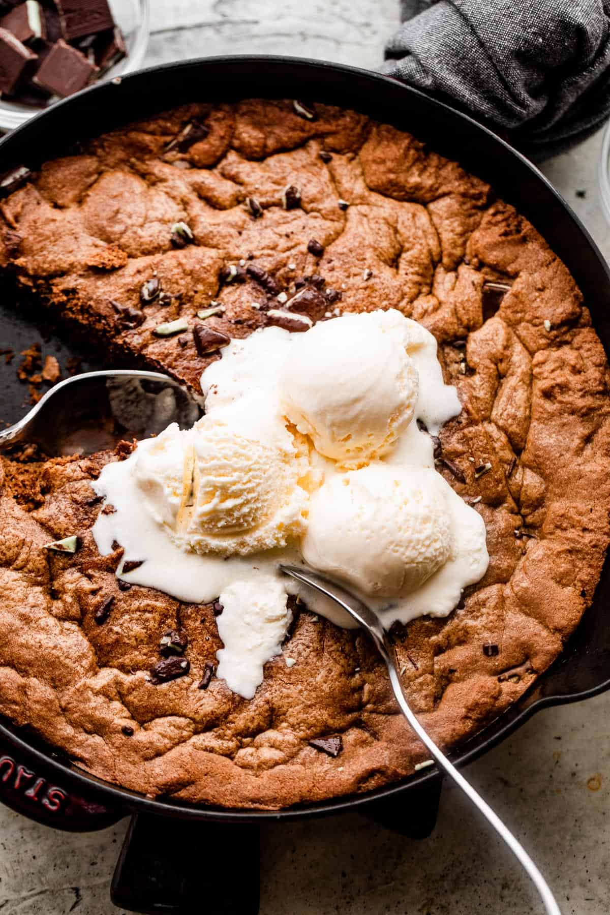 overhead shot of a skillet cookie topped with three scoops of vanilla ice cream