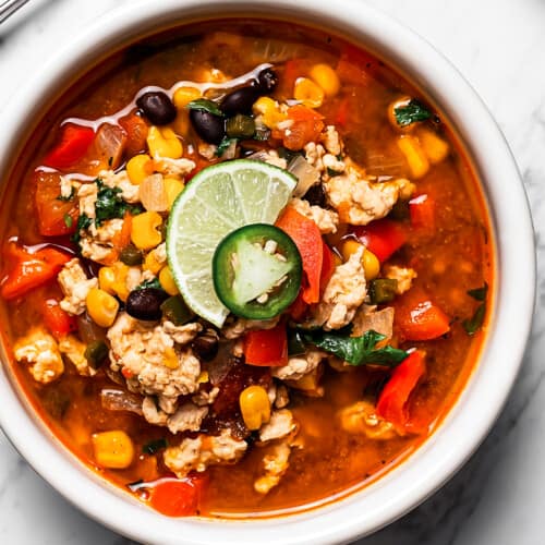 Easy taco soup in a bowl with a lime wedge, jalapeño, and cilantro on top.
