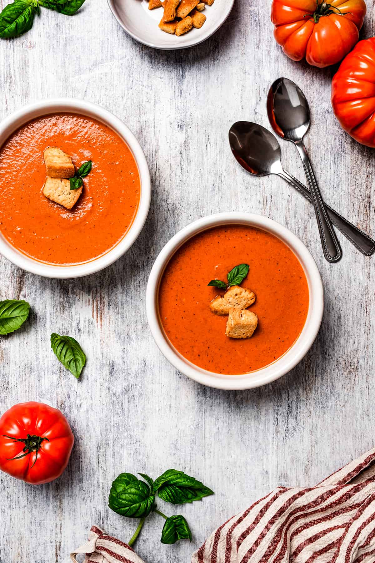 Two bowls of creamy tomato bisque.