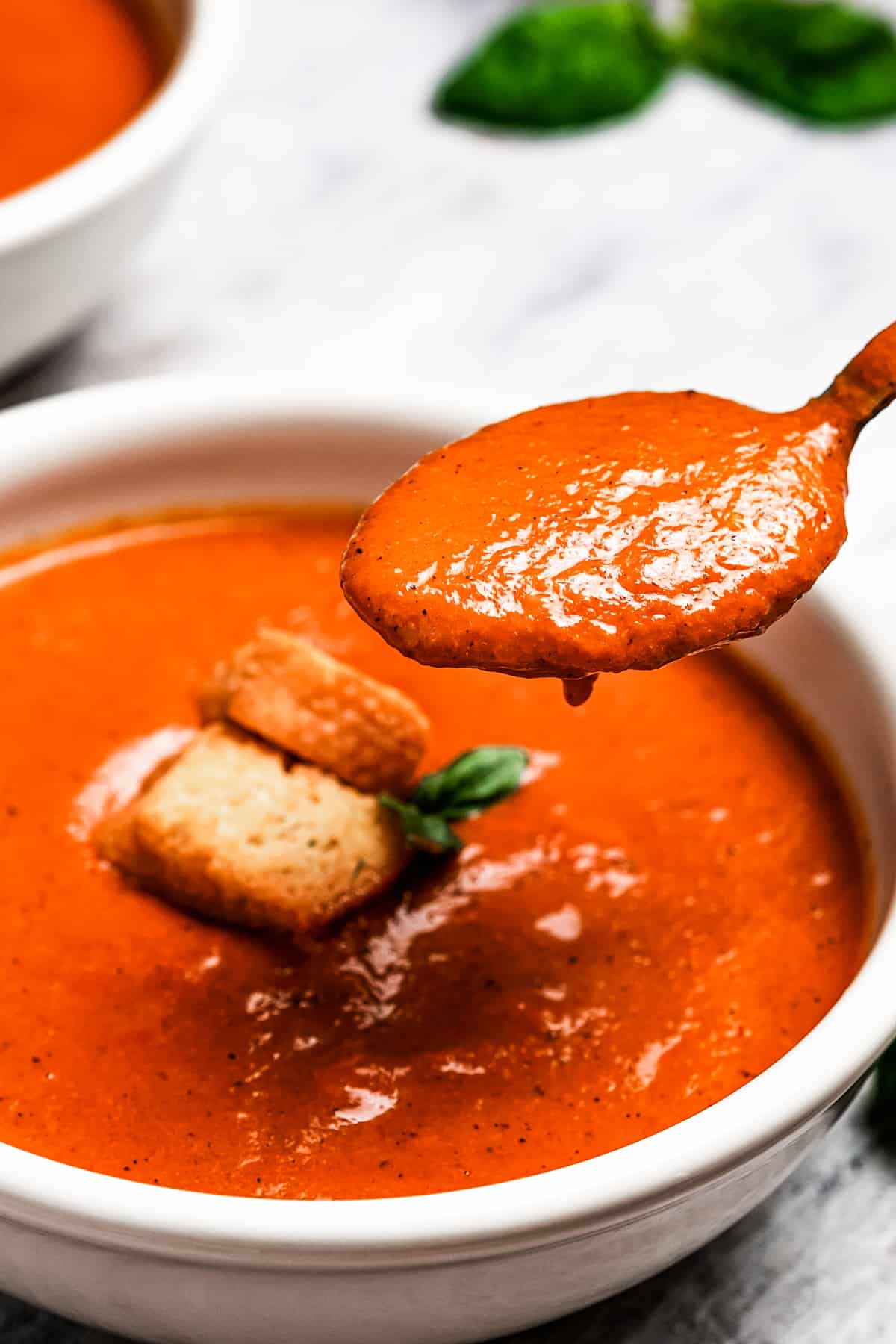 spooning out tomato bisque.