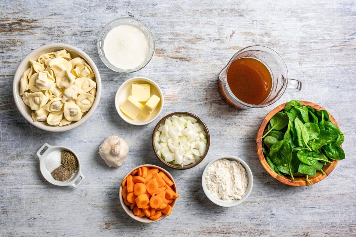 Creamy Tortellini Soup with spinach is an easy vegetarian soup recipe packed with tender cheese tortellini, fresh veggies, and lots of flavor! The ingredients for tortellini soup arranged on a table.