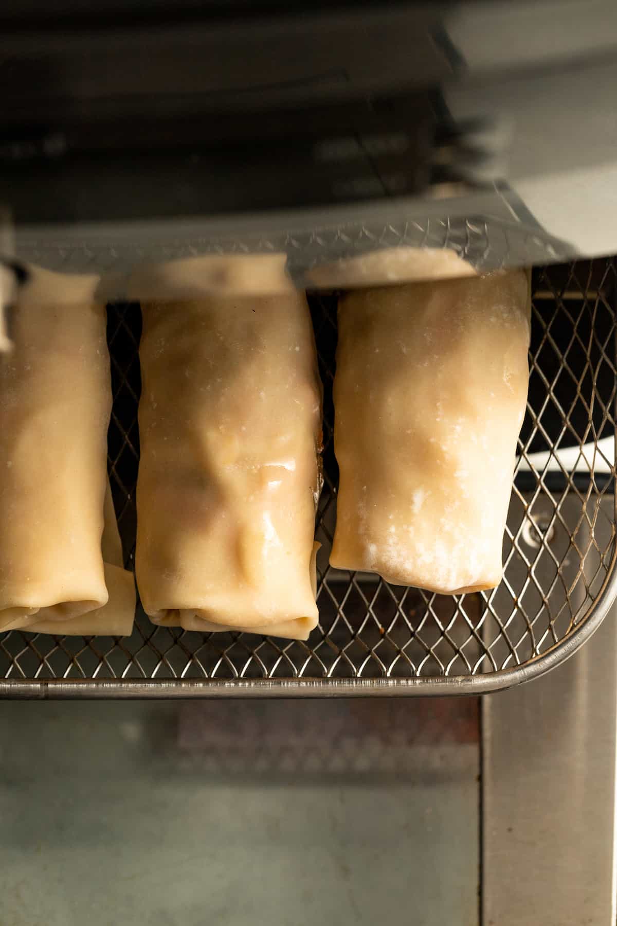 Adding the spring rolls to the air fryer.