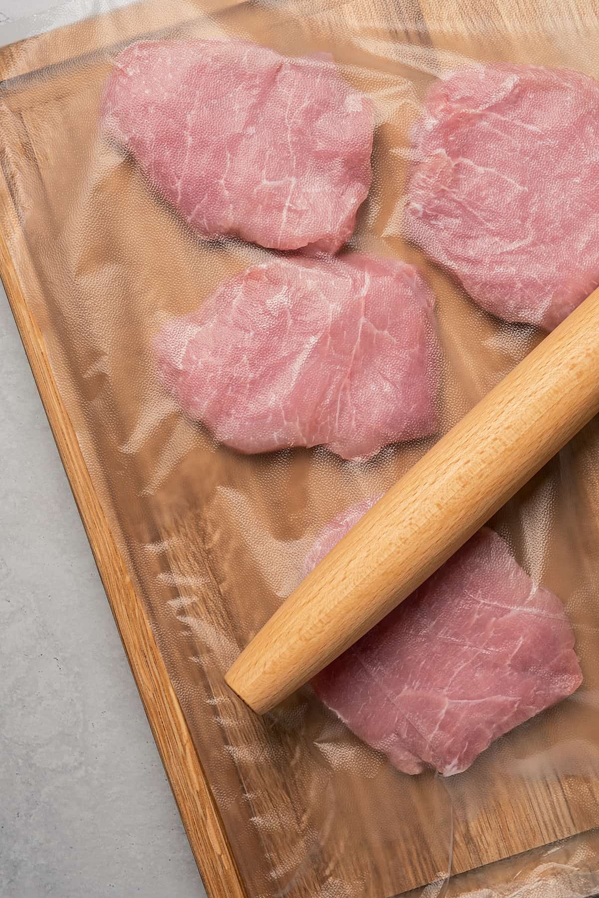 Pounding cutlets thin with a rolling pin.
