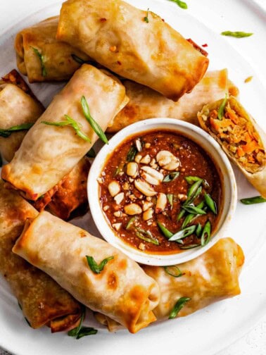 Air fryer spring rolls with peanut sauce on the side.