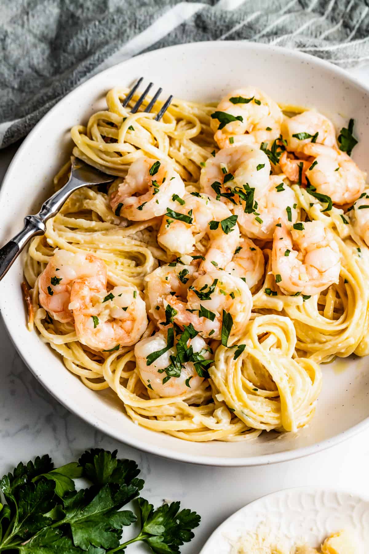 Angled shot of a large bowl with homemade alfredo pasta with shrimp.