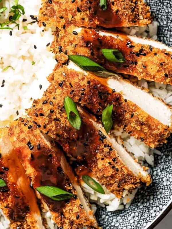 Close-up of chicken katsu with tonkatsu sauce over rice.