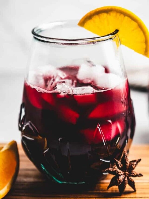 Close-up of glass of Jamaican sorrel with an orange wedge.